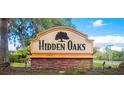 Hidden Oaks community entrance sign with stone base and oak tree logo at 3390 Cedar Spring Pl # 163, Winter Park, FL 32792