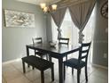 Bright dining room with table, bench, and chairs, featuring large window and wall art at 3715 Eisel Way, Haines City, FL 33844