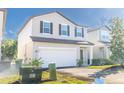 Two-story house with a white garage door and landscaping at 2076 Cades Cove Way, Deland, FL 32720