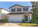 Two-story house with a white garage door and landscaping at 2076 Cades Cove Way, Deland, FL 32720
