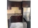 Galley kitchen with dark cabinets and granite counters at 2802 N Powers Dr # 18, Orlando, FL 32818