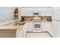 White kitchen with stainless steel appliances and light countertops at 3177 Feltrim Pl # 104, Kissimmee, FL 34747