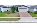 House with gray siding, brick driveway, and small front yard at 416 Mckenna Dr, Winter Haven, FL 33881