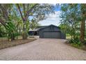 Gray house with brick paver driveway, mature landscaping, and a two-car garage at 4834 Hall Rd, Orlando, FL 32817