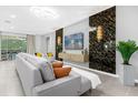 Open living area with a large screen TV, comfortable seating and a stylish wall design at 8881 Qin Loop, Kissimmee, FL 34747