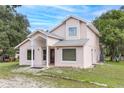 Two-story house with covered entry and dark brown door, surrounded by trees at 23035 Fort Christmas Rd, Christmas, FL 32709