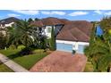 Two-story house with brown tile roof, light-colored siding, and a three-car garage at 16659 Broadwater Ave, Winter Garden, FL 34787