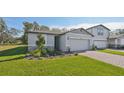 Two story home with gray siding, stone accents, and a two-car garage at 28066 Poppy Ct, Leesburg, FL 34748