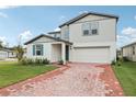 Two-story house with brick paver driveway and landscaping at 4710 Jasmine Ct, Leesburg, FL 34748
