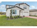 Two-story house with gray siding, blue shutters, and landscaping at 4710 Jasmine Ct, Leesburg, FL 34748