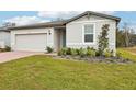 One-story house with gray siding, brick paver driveway, and well-manicured lawn at 4736 Jasmine Cir, Leesburg, FL 34748