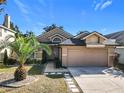 House exterior showcasing a two-car garage and landscaping at 4929 Dunmore Ln, Kissimmee, FL 34746