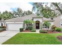 Exterior view of a single story home with stone accents and mature landscaping at 3984 Beacon Ridge Way, Clermont, FL 34711