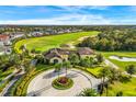 Community clubhouse with circular driveway and palm trees at 7824 Whitemarsh Way, Reunion, FL 34747