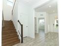 Bright and airy entryway with wood stairs and tile flooring at 7916 Waterfield Ave, Orlando, FL 32832