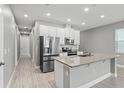 Modern kitchen with stainless steel appliances and island at 6886 Wilson Hammock Ave, Groveland, FL 34736