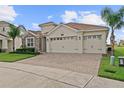 A charming two-story house with a three-car garage and a landscaped front yard at 1142 Trappers Trail Loop, Davenport, FL 33896