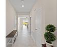 Bright and spacious entryway with tile flooring and a wooden bench at 1142 Trappers Trail Loop, Davenport, FL 33896