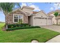 Two-story house with three-car garage and stone exterior at 1142 Trappers Trail Loop, Davenport, FL 33896