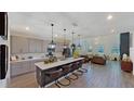 Open concept kitchen with island, stainless steel appliances, and white quartz countertops at 2277 Derwent Dr, Davenport, FL 33896
