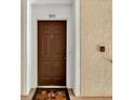Condo entry with brown door and Mickey Mouse mat at 6214 Stevenson Dr # 303, Orlando, FL 32835