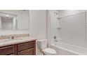 Bathroom with granite countertop, dark brown vanity, and a bathtub at 1209 Limbali St, Mount Dora, FL 32757