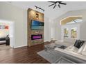 Open living area with a stone fireplace and large TV at 2660 Oneida Loop, Kissimmee, FL 34747