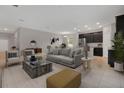 Open living room and kitchen with modern gray sofa and dark kitchen cabinets at 3577 Dahlia Dr, Lake Hamilton, FL 33851