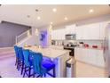 Modern kitchen with white cabinets and a breakfast bar at 606 Jasmine Ln, Davenport, FL 33897