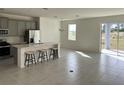 Open concept kitchen with gray cabinets, island, and tile flooring at 6817 Serpent Hawk Lane St, Howey In The Hills, FL 34737