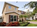 Two story house with tan siding, brown shutters, and lush landscaping at 9036 Arbors Edge Trl, Windermere, FL 34786