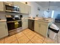 Updated kitchen with stainless steel appliances, light green cabinetry, and white countertops at 148 Brunello Dr, Davenport, FL 33897