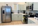 Modern kitchen boasts stainless steel appliances, light green cabinets, and white countertops at 148 Brunello Dr, Davenport, FL 33897