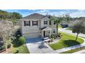 Two-story house with a two-car garage and landscaped lawn at 2056 Marabou Dr, Davenport, FL 33896