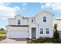 Two-story house with a gray exterior and brick driveway at 27472 Black Kite Ave, Howey In The Hills, FL 34737