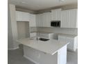 Modern kitchen featuring white cabinets, quartz countertops, and an island at 783 Pilea St, Apopka, FL 32703