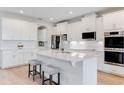 Modern kitchen with white cabinets, quartz countertops, and stainless steel appliances at 9849 Lost Creek Dr, Winter Garden, FL 34787