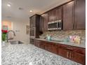 Modern kitchen with dark cabinets and granite countertops at 108 Burlington Pl, Poinciana, FL 34758