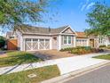 Charming house with neutral siding, a two-car garage and professionally landscaped front yard at 349 Alcove Dr, Groveland, FL 34736