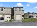 Two-story townhome with a two-car garage and a small front yard at 470 Lake Shore Pkwy, Davenport, FL 33896