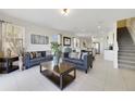 Open living room with gray sofas, a coffee table, and views into the kitchen and dining area at 470 Lake Shore Pkwy, Davenport, FL 33896