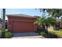 Orange house exterior with a two-car garage and palm trees at 836 Grand Canal Dr, Kissimmee, FL 34759