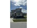 Two-story house with light brown siding, shutters, and a paved driveway at 8918 Tropical Haven Ct, Kissimmee, FL 34747