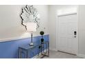 Modern entryway with glass-top console table, mirror, and stylish decor at 1540 Maidstone Ct, Davenport, FL 33896