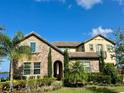 Two-story home with stone accents and a three-car garage at 16779 Broadwater Ave, Winter Garden, FL 34787