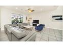 Spacious living room featuring a gray sectional sofa and access to backyard at 2468 Dubai St, Kissimmee, FL 34747