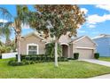 One-story house with tan exterior, two-car garage, and manicured lawn at 3258 Spicer Ave, Grand Island, FL 32735