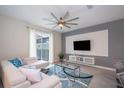 Bright living room with white sectional sofa, large TV, and stylish decor at 4819 Memories Ln, Kissimmee, FL 34746