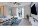 Living room with white sectional sofa, glass coffee table, and access to patio at 4819 Memories Ln, Kissimmee, FL 34746