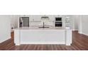 Modern kitchen island with white cabinets and quartz countertop at 15065 Willow Ridge Dr, Montverde, FL 34756